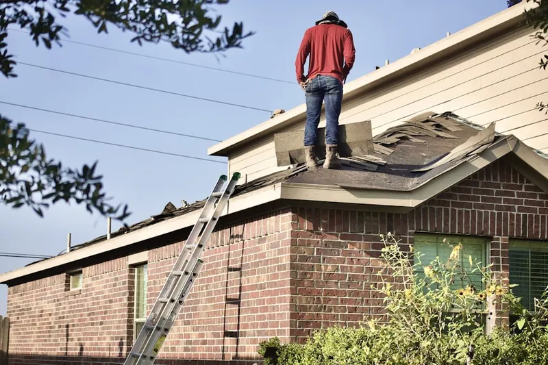 Professional roofer working on a residential roof in Flohrville